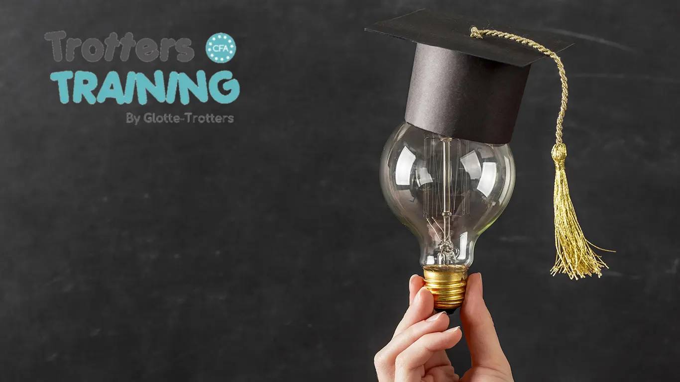 Main tenant une ampoule avec toque de diplômé, symbolisant la réussite grâces aux offres d'apprentissage en petite enfance du CFA Trotters Training.