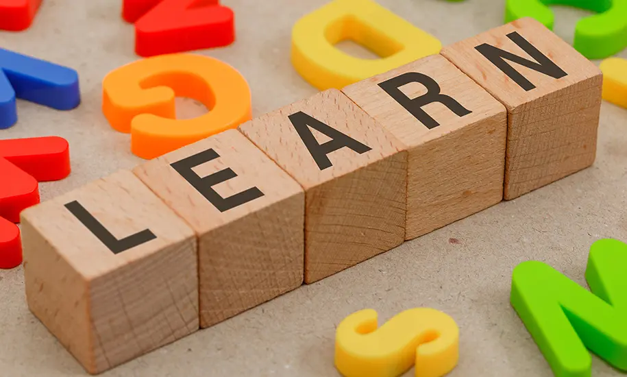 courrs d'anglais pour les professionnels de la petite enfance illustrés par le mot “LEARN” formé avec des blocs en bois.